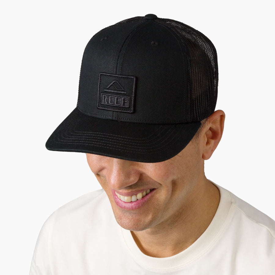 Man wearing a black Tonal Townsend Hat facing forward, surf-inspired with comfort and breathable mesh back.