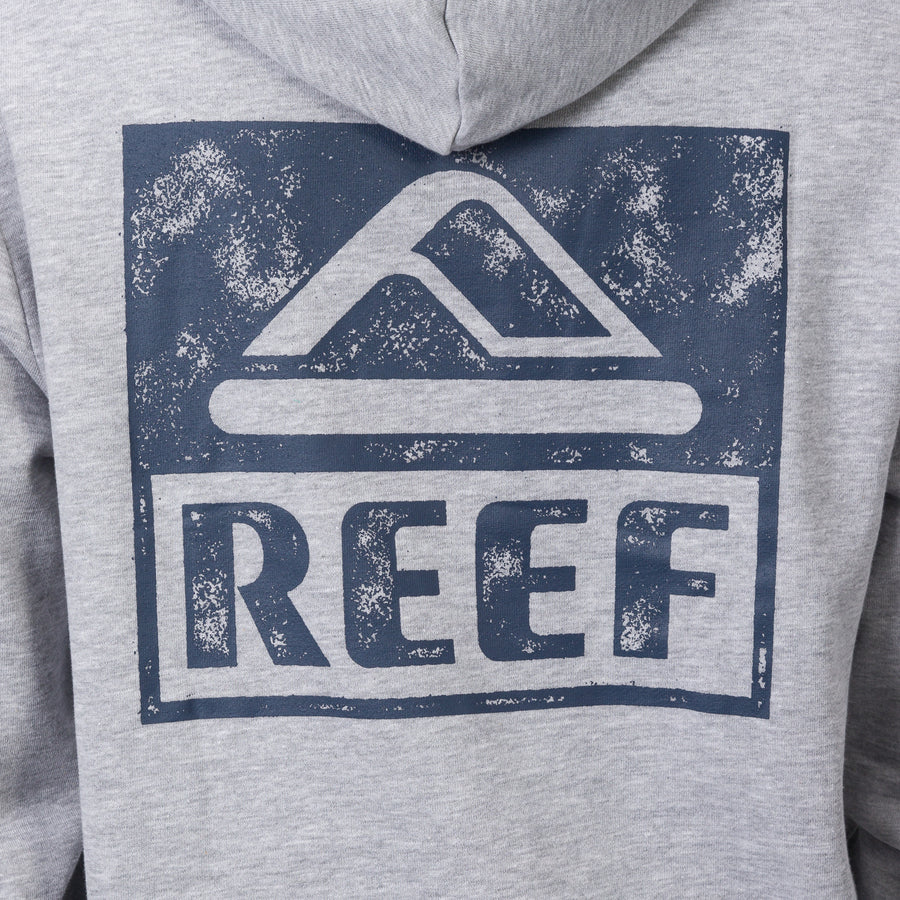 Close-up of the back of a grey Wellie Too Hoodie featuring a distressed blue REEF logo print, beach-inspired comfort apparel.
