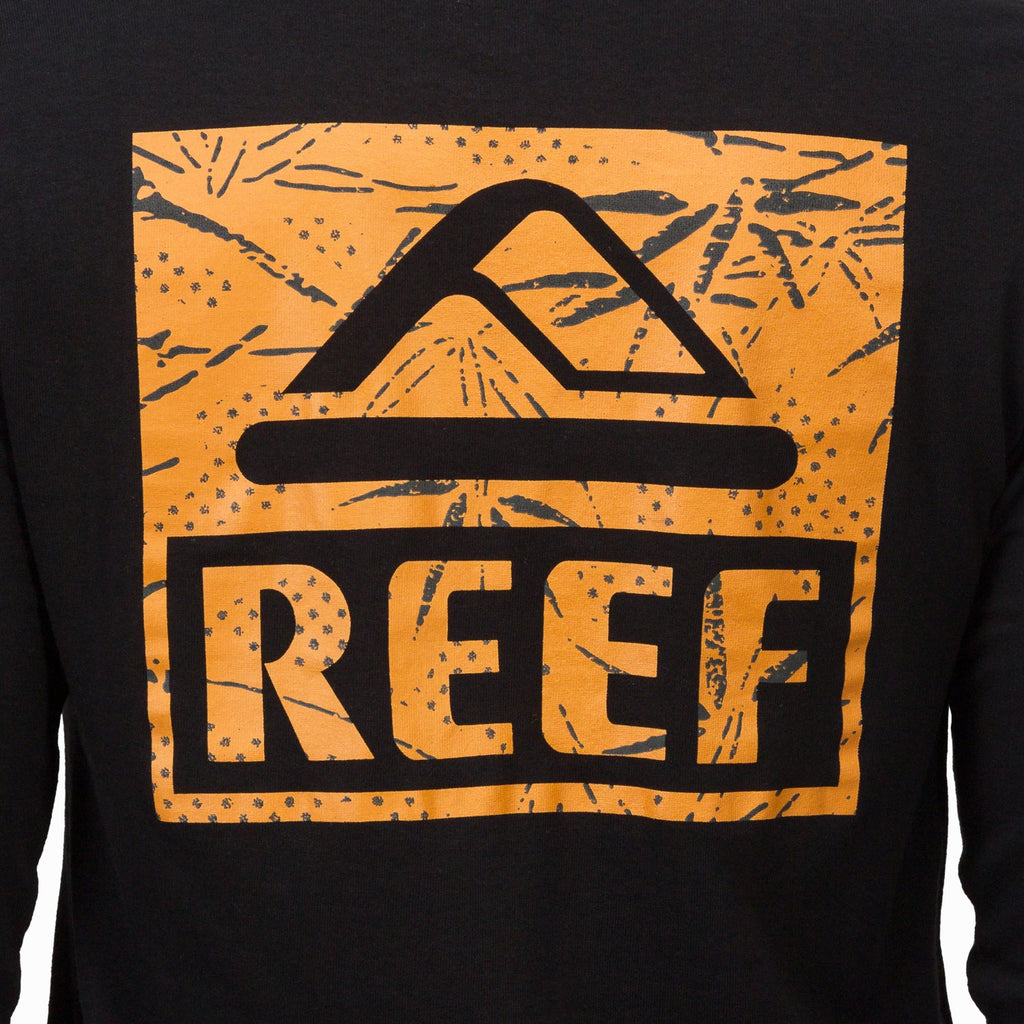 Close-up of the chest logo on the black Wellie 24 Long Sleeve Tee featuring surf-inspired design and comfort-focused fabric.