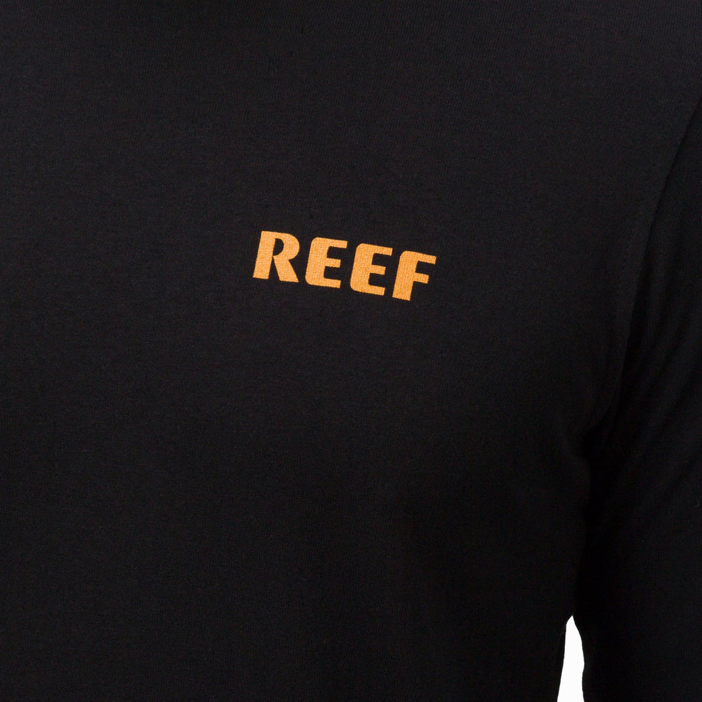 Close-up of the chest area on a black Wellie 24 Long Sleeve Tee featuring the orange REEF logo, comfort-focused apparel.