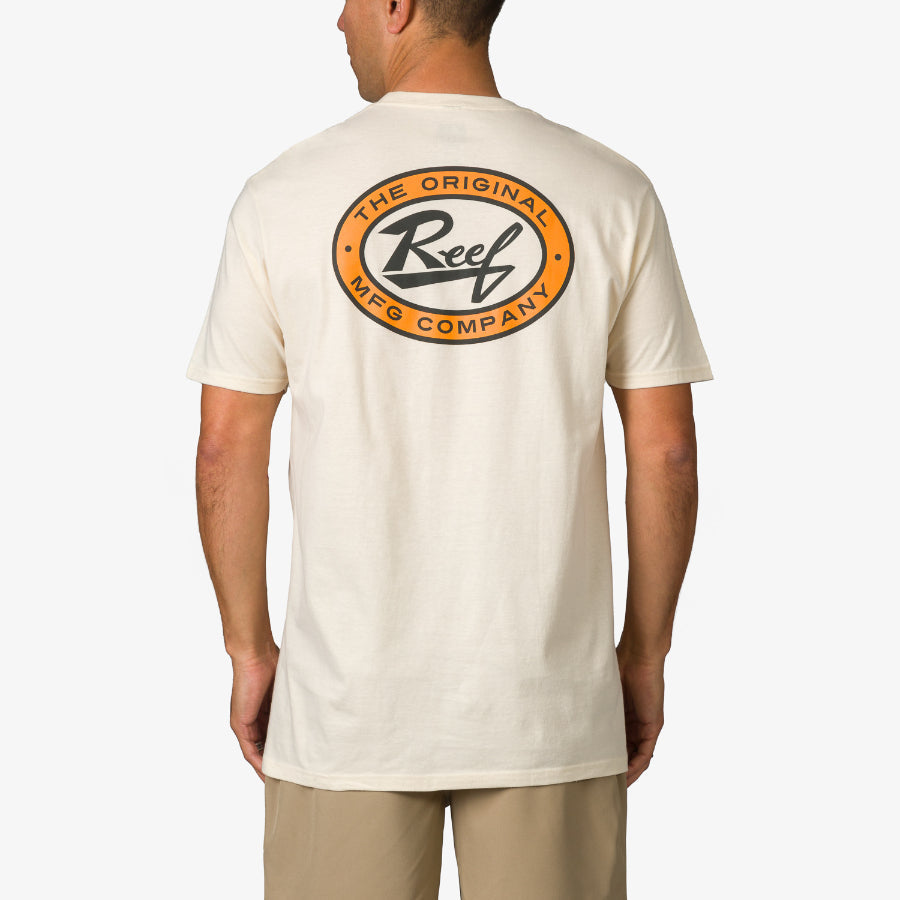 Man wearing cream-colored Auto Tee showing back with round orange and black Reef logo, standing facing away from camera