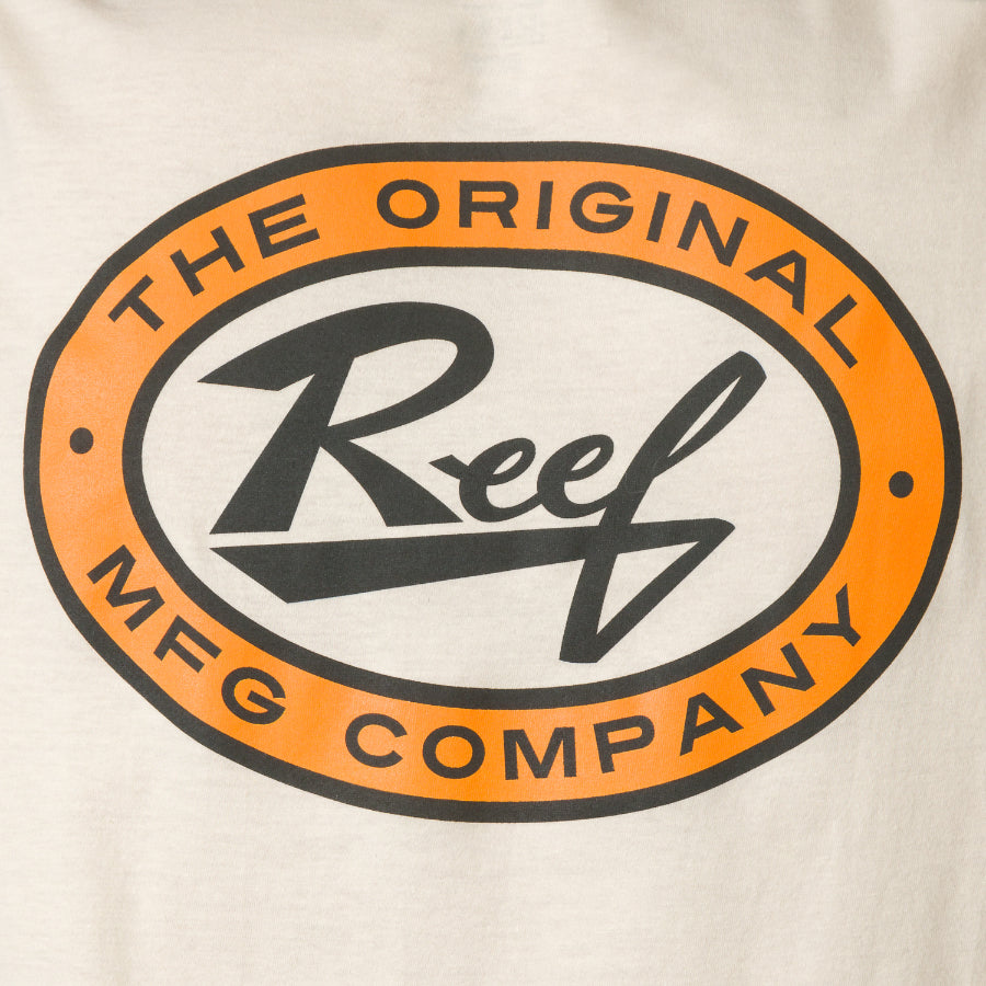 Close-up of the chest logo on the cream Auto Tee, featuring bold orange and black Reef branding, beach-inspired style.