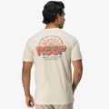 Man wearing the back view of the Quinn Tee with a colorful REEF logo and beach-inspired graphic in cream color