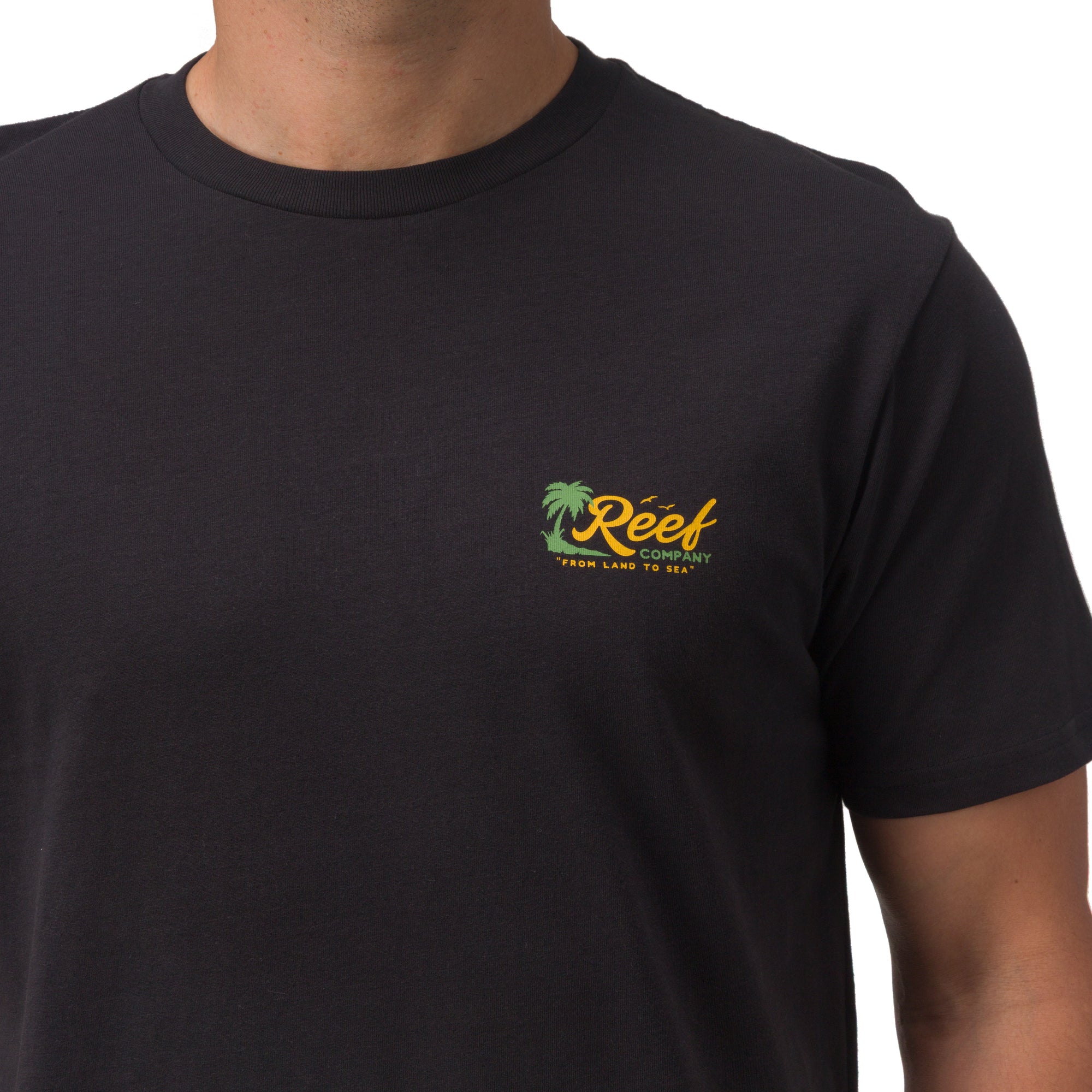 Men wearing a black Isac Tee showing chest logo with surf-inspired, comfort-focused casual apparel design.