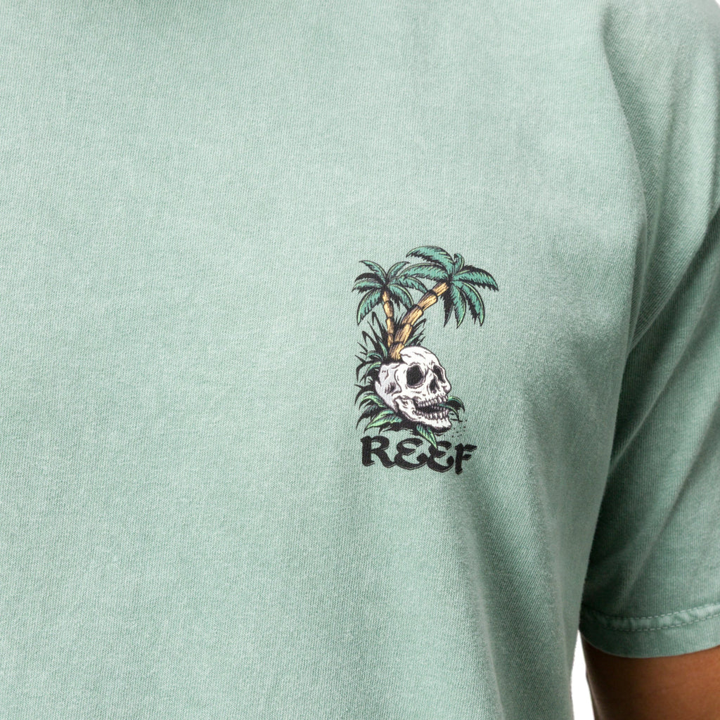 Close-up of the chest on a men's Akin Tee in muted green with Skull and palm tree surf-inspired graphic design