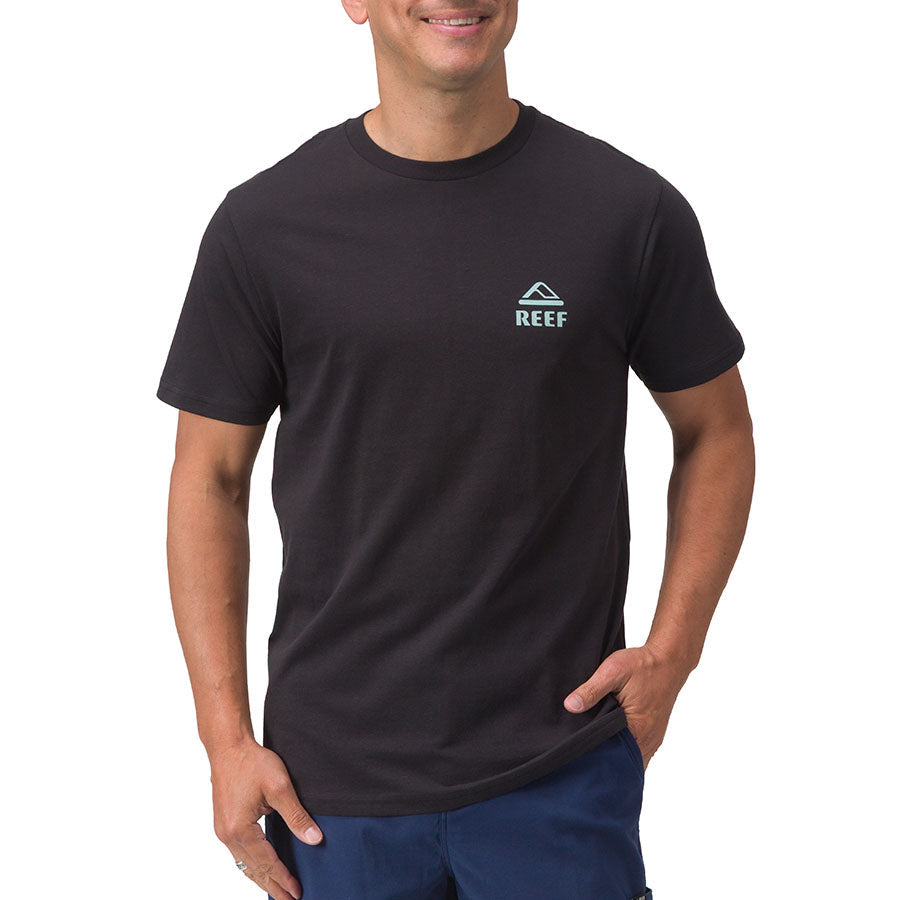 Front view of a man wearing a black Shells Tee by REEF, designed for comfort and beach-inspired casual wear.