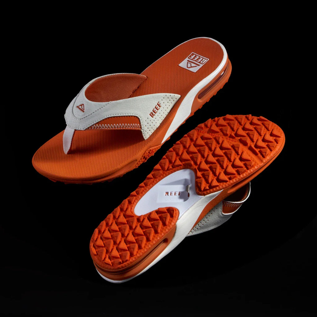 Fanning Pregame men’s sandal facing left with white straps and orange sole, showing top and rugged bottom tread design.