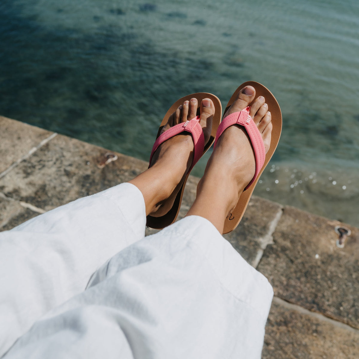 Reef Cushion Breeze sandals in strawberry pink facing forward on feet, showing soft-rebound cushioning and arch support.