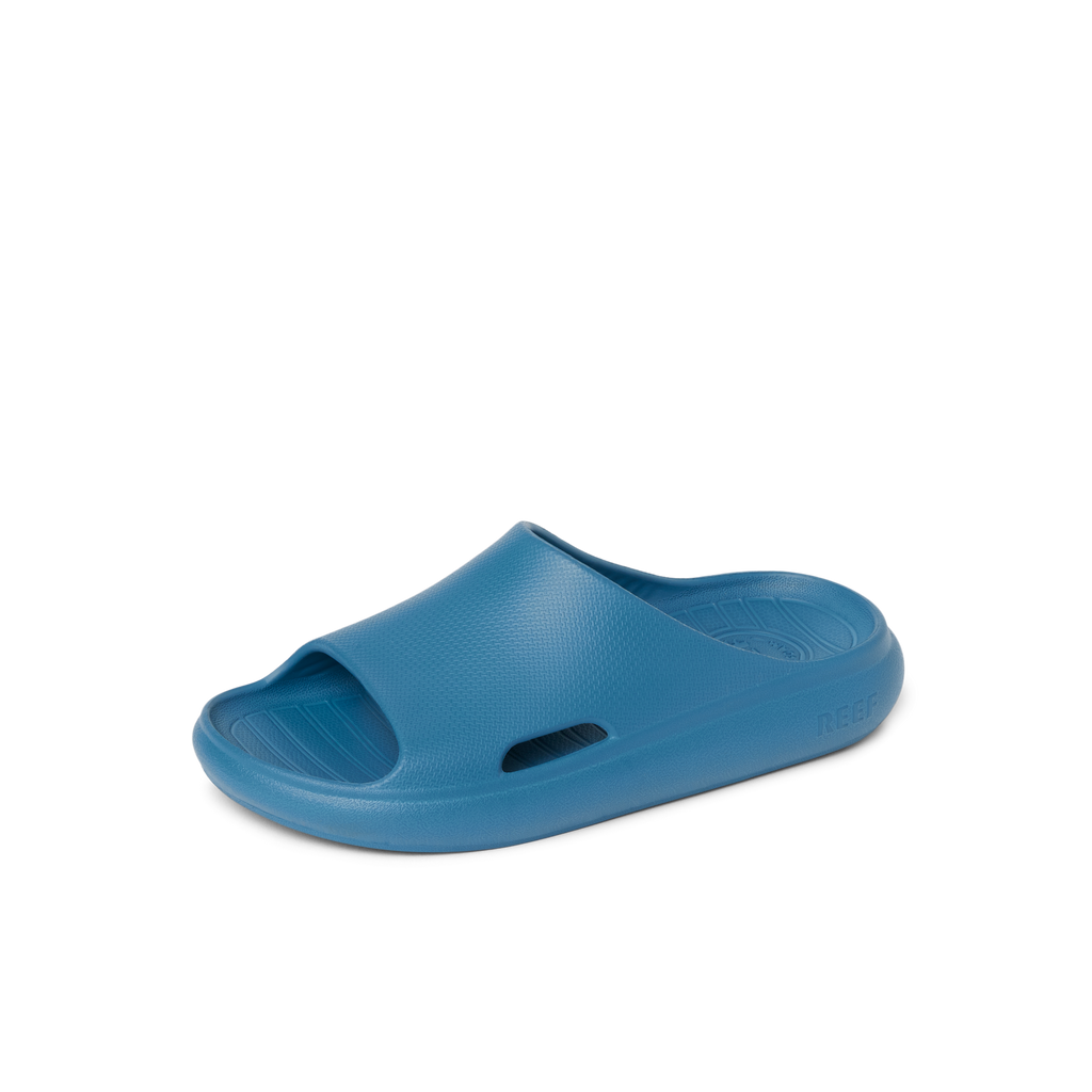 Kids Rio Slide in blue, right-facing, close-up of top and side, featuring soft cushioning and water-friendly design.