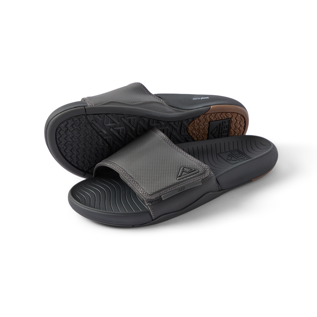 Pair of men's Phantom Slab slides in black facing forward, showing soft-rebound cushioning and anatomical arch support.