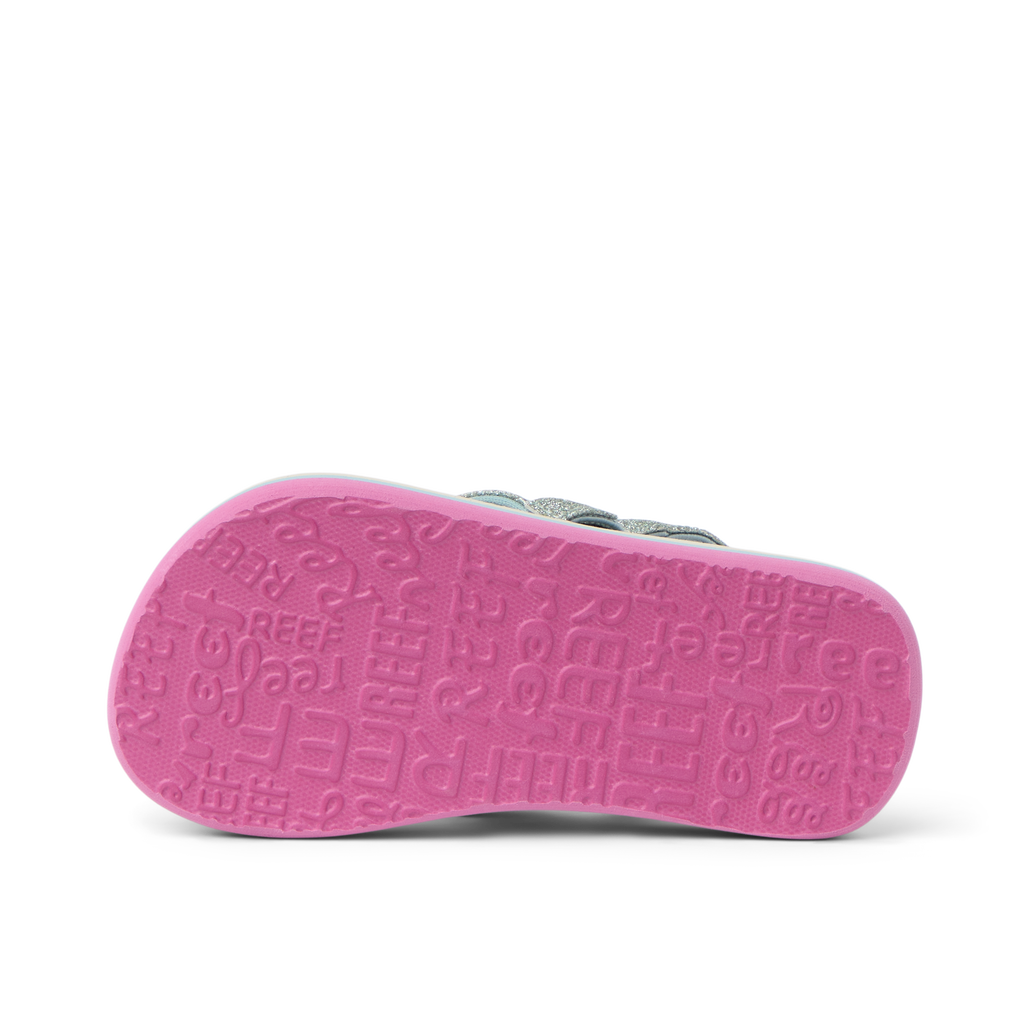 Little Ahi girls’ sandal showing bottom sole facing up with pink textured REEF logo pattern, beach comfort design.
