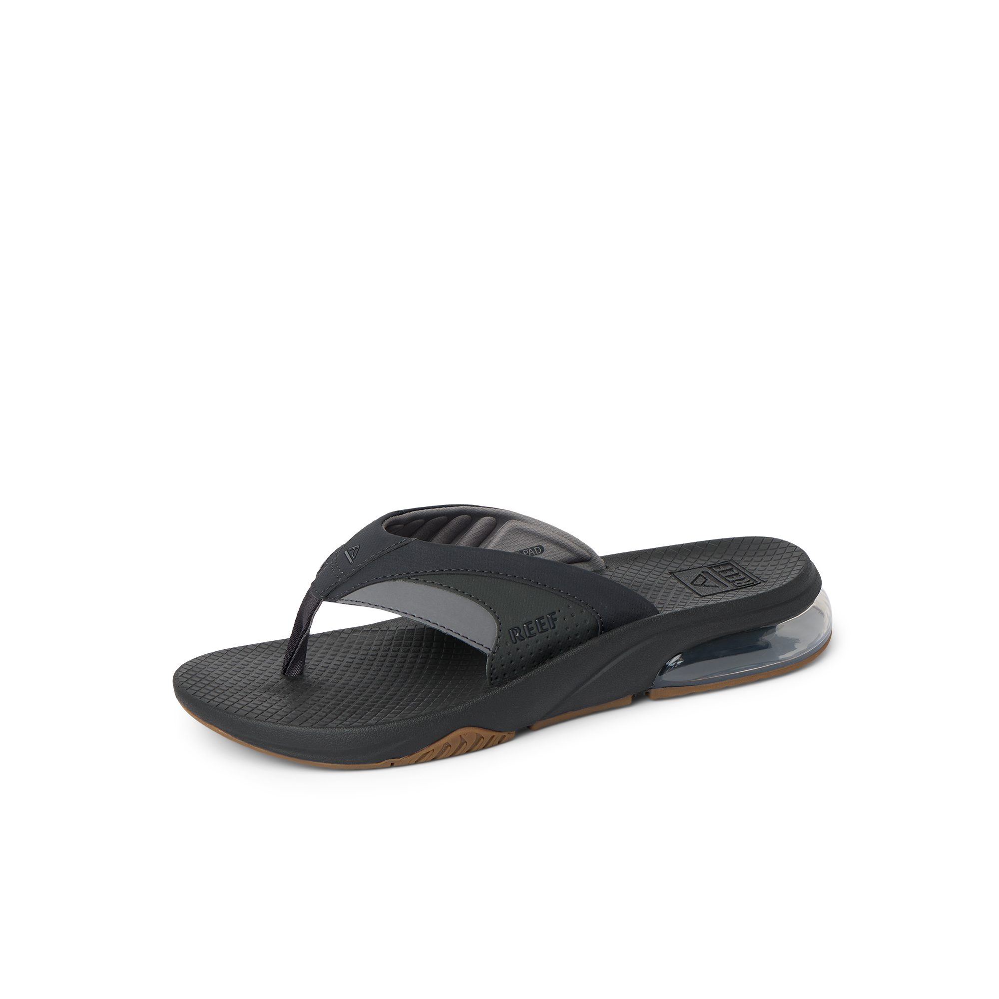 Fanning + men’s black and gum flip flop facing right, close-up of padded toe post and cushioned arch support.
