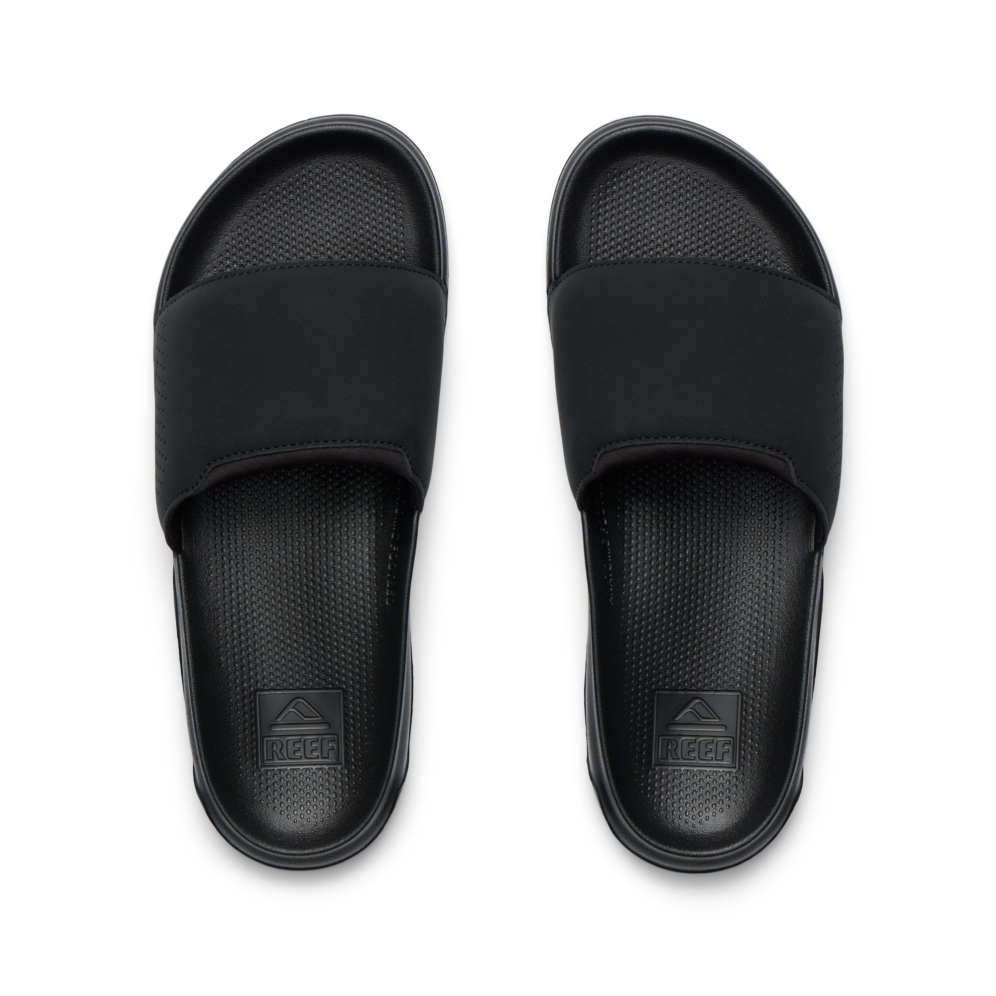 Tailslide men's black slides facing up, close-up of footbeds with textured cushioning and arch support for water-friendly comfort.