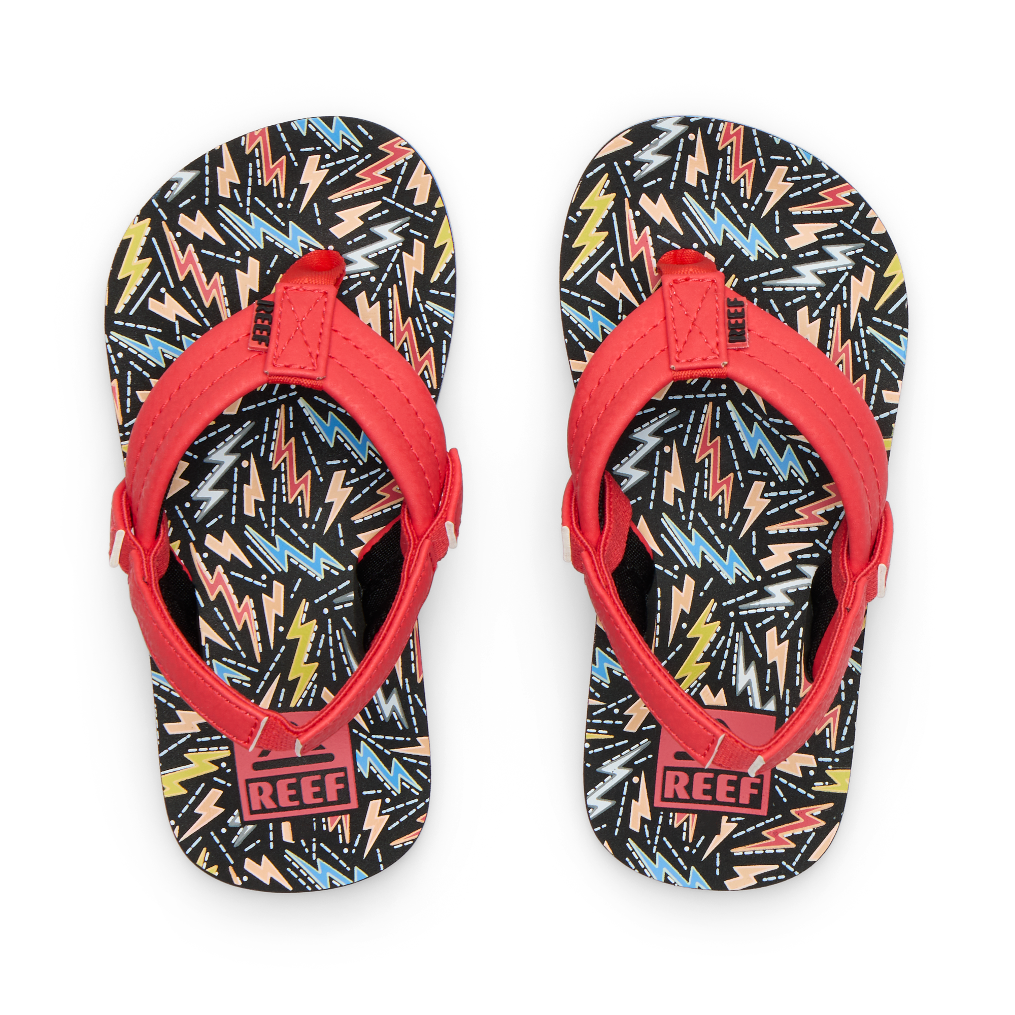 Little Ahi boys flip flops with red straps facing upward, featuring colorful bolt pattern, soft cushioning, and arch support.