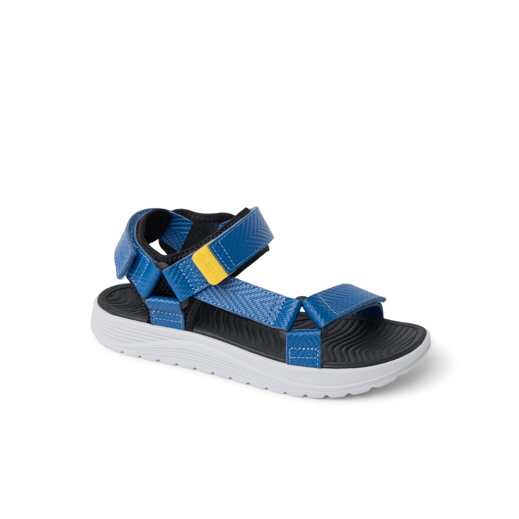 Kids Shoremazing sandal facing left, blue straps with yellow detail, black footbed, white sole, durable water-friendly design.