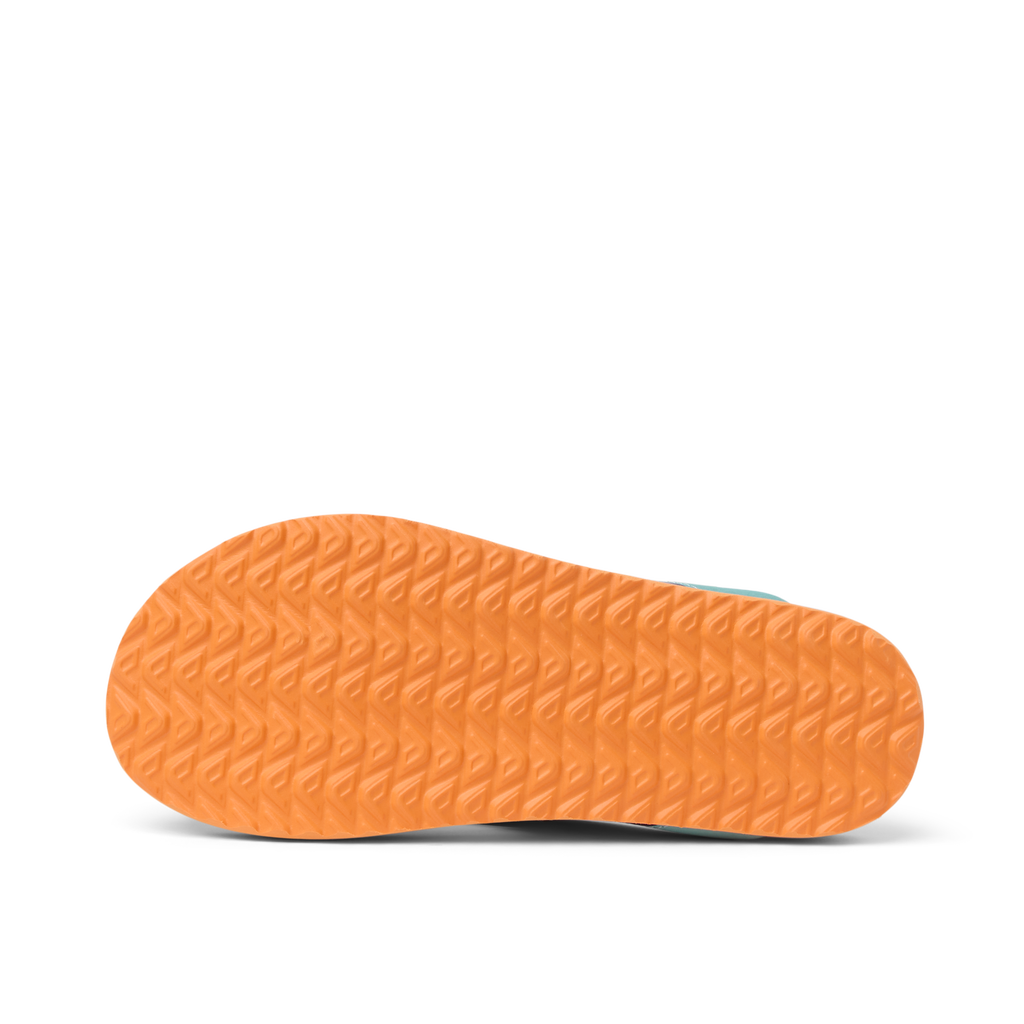 Kids Windswell left flip flop outsole close-up showing durable orange tread pattern for beach comfort and grip.