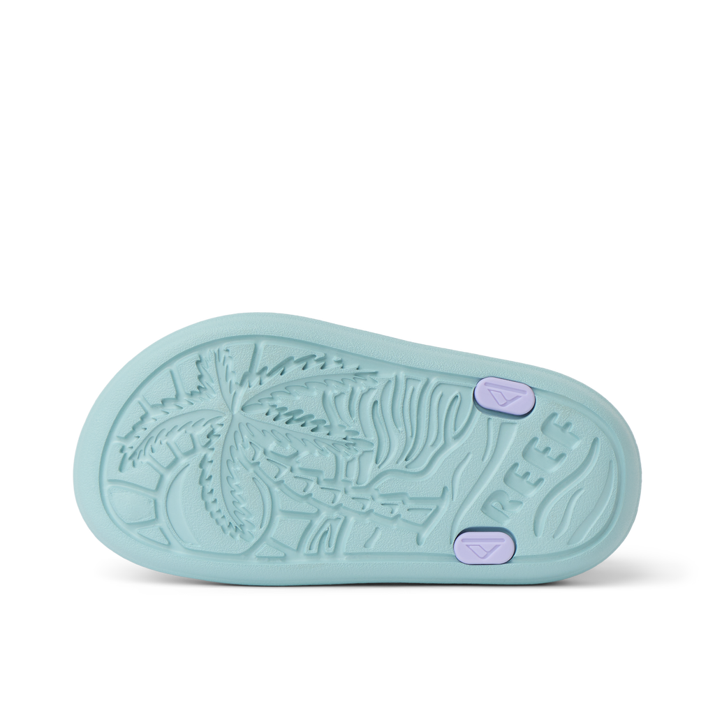 Little Totally Beachin sandal sole facing up, showing textured palm tree pattern and REEF logo, designed for comfort.