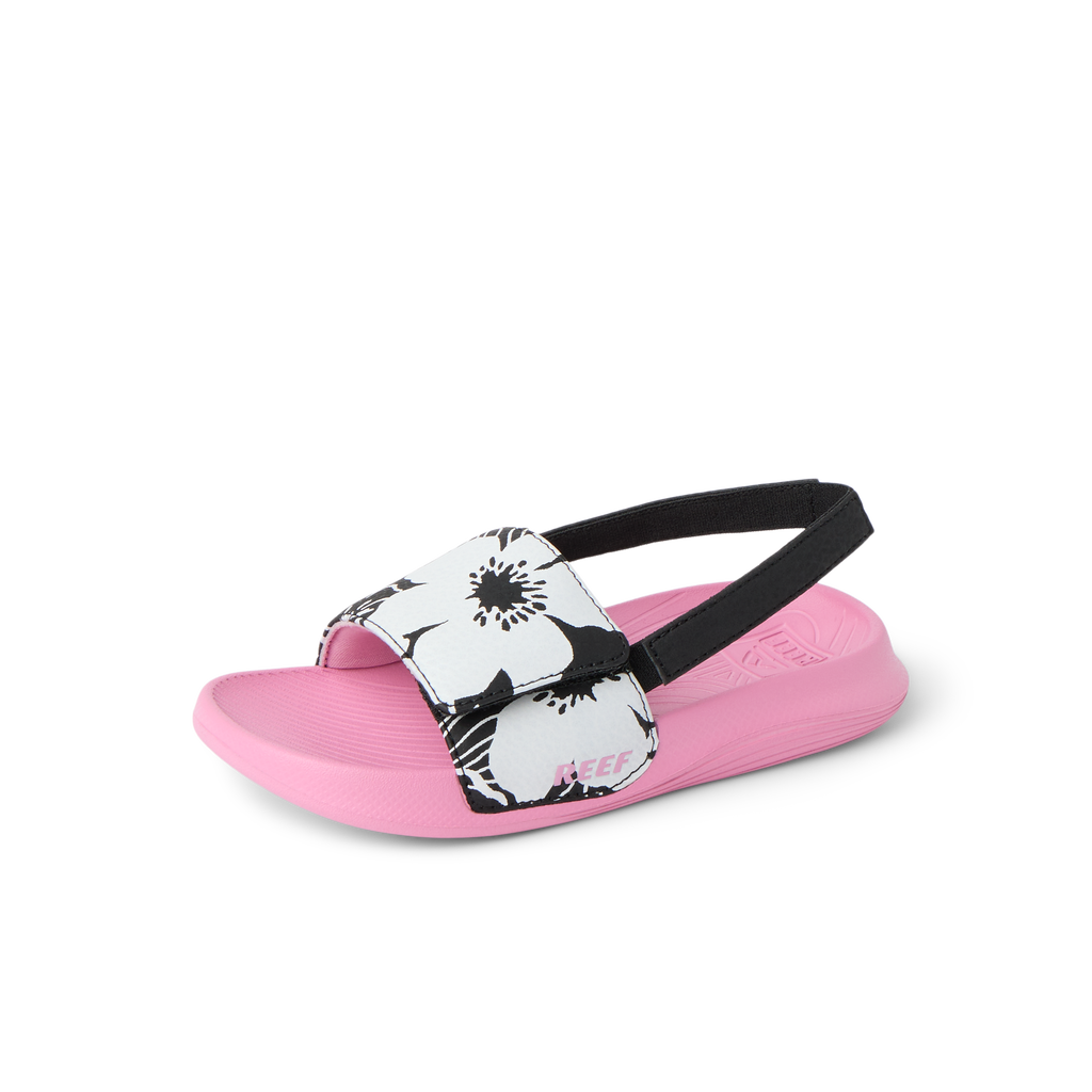 Little Salty Slide sandal for girls facing left, showing soft pink sole, black and white floral strap, and black heel strap.