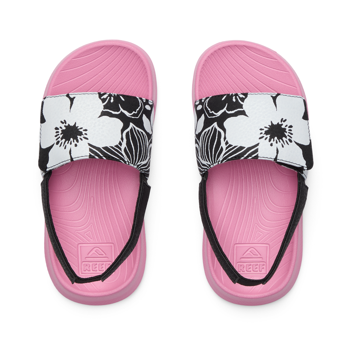 Top view of pink Little Salty Slide sandals for girls with black and white floral straps, designed for comfort and beach use.