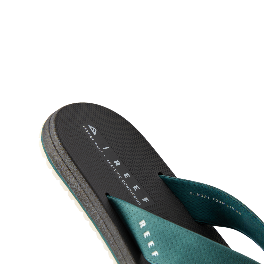 Nox men’s sandal facing left, close-up of the footbed and teal strap with memory foam for beach comfort.