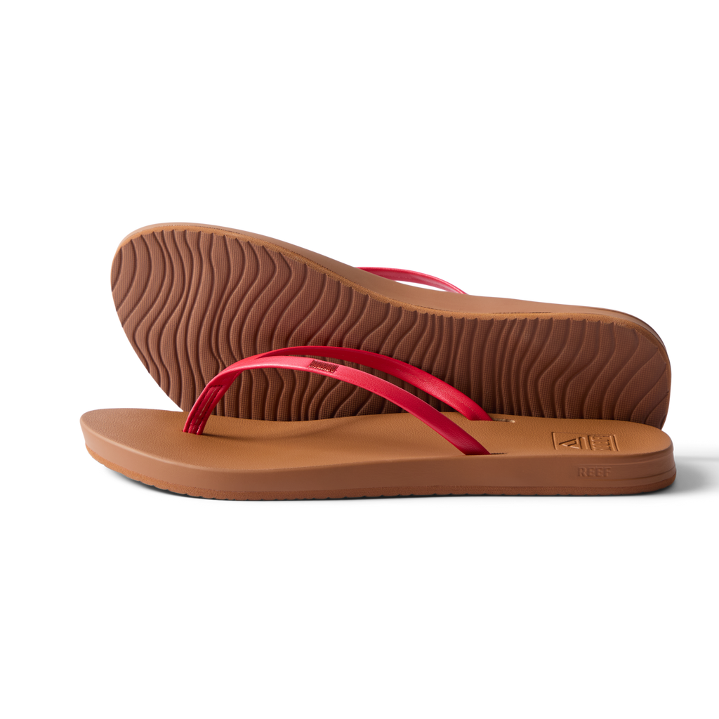 Pair of Cushion Slim women's sandals facing right, side and sole view, red straps, beach-inspired water-friendly design.