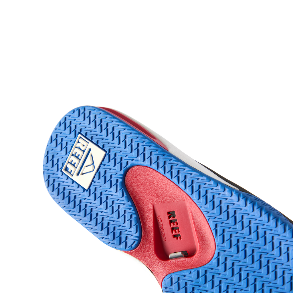 Fanning men's footwear close-up of outsole facing up showing textured blue rubber sole with anatomical arch support in red.