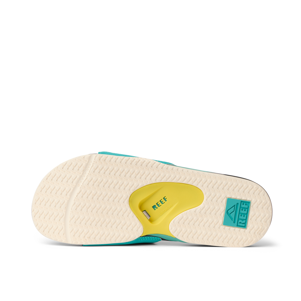 Fanning Slide showing bottom sole facing up with teal, yellow, and black colors, highlighting comfort and durability features.