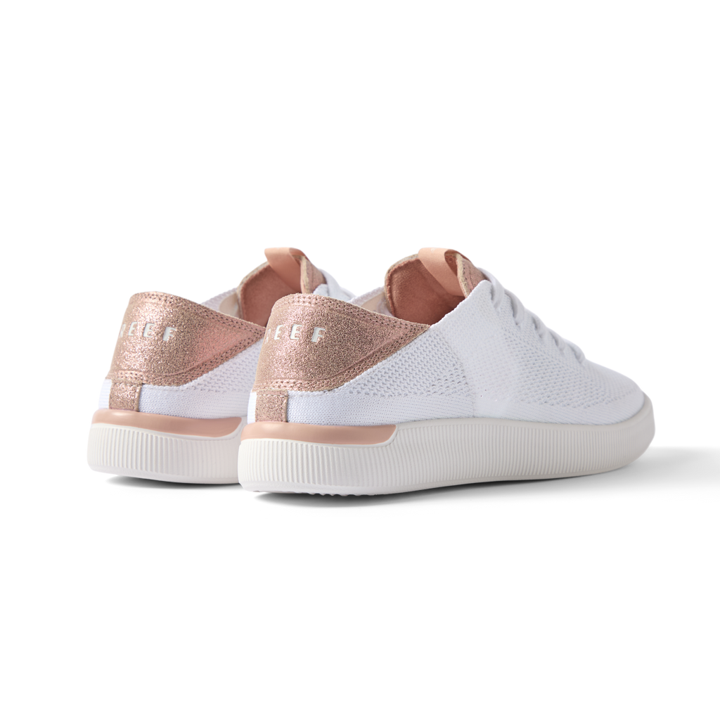 Reef Neptune women's white shoe with rose gold heel counter facing backward, showcasing cushioned, breathable design.