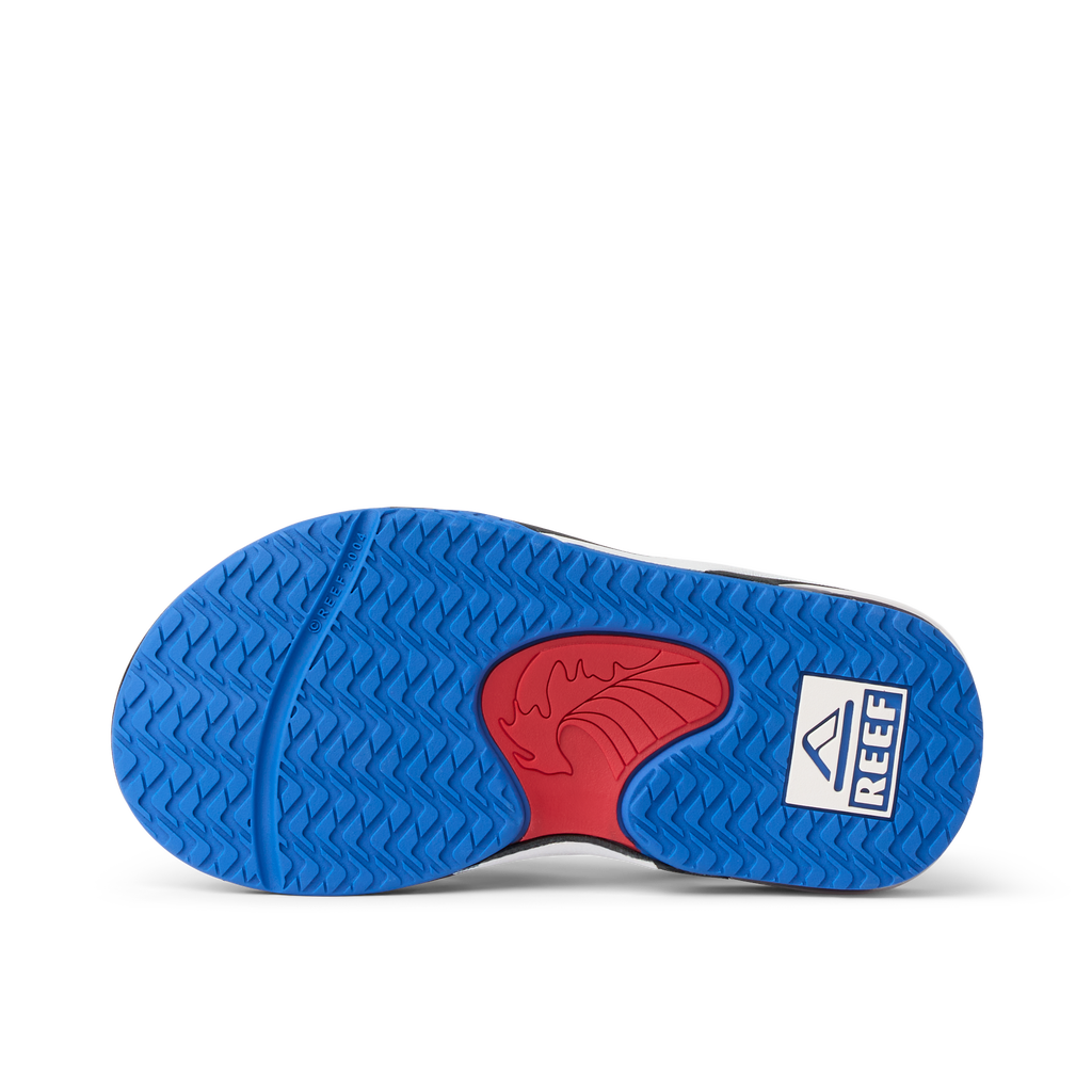 Little Fanning boys’ sandal sole facing up showing blue and red water-friendly outsole with Reef logo for comfort.