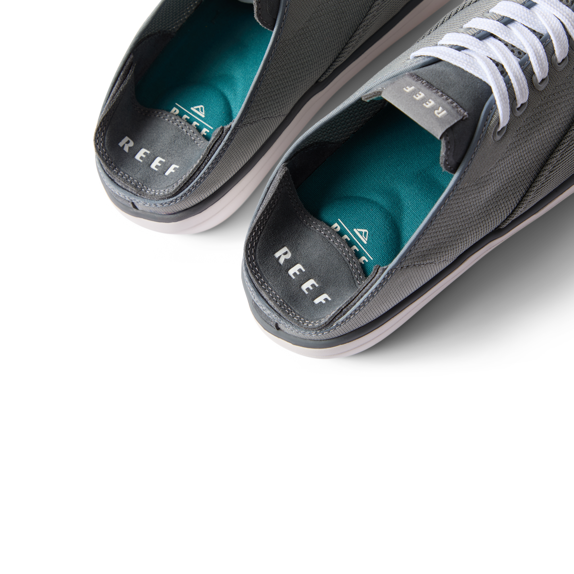 Top view close-up of Neptune Lido men's grey shoes facing upward, showing cushioned teal insoles and REEF branding.