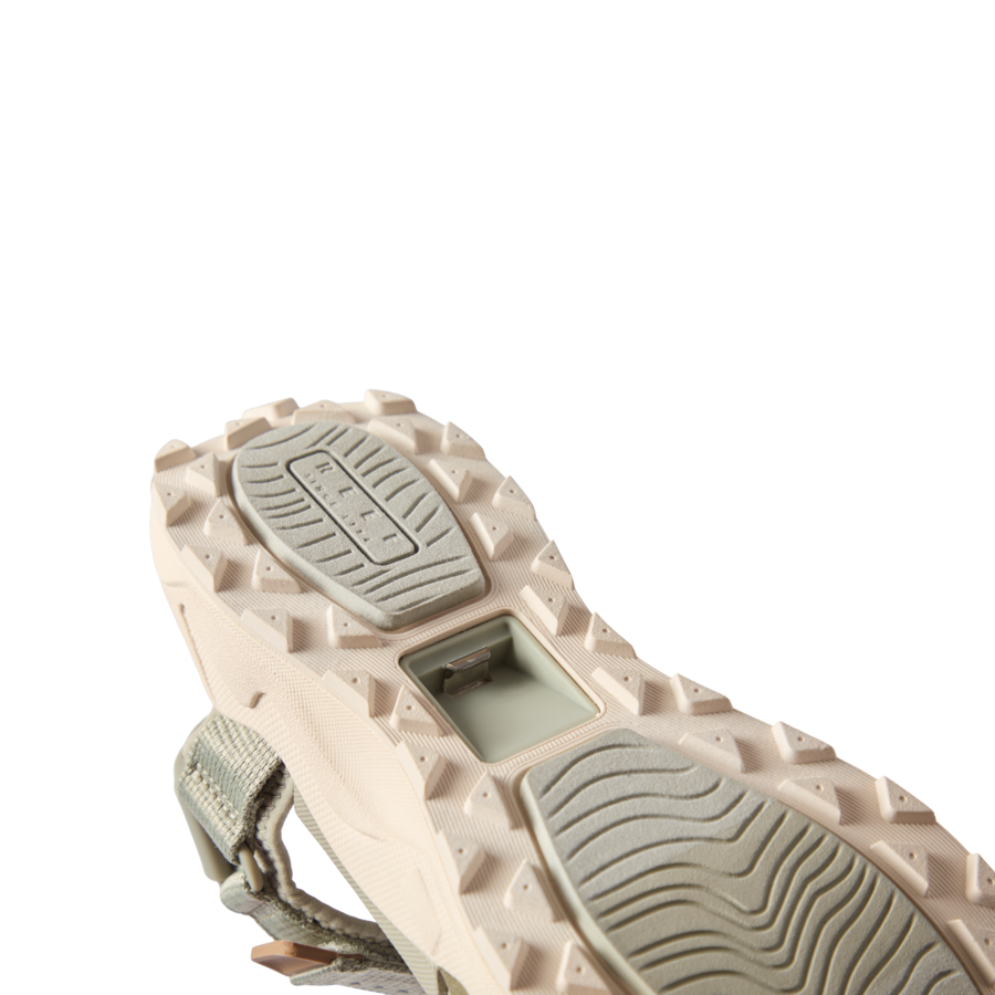Cross-Shore men's shoe sole facing upward showing textured grip and built-in bottle opener for beach and active lifestyles.