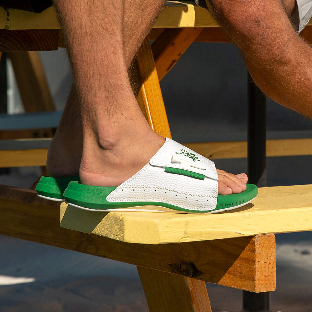 Cruiser Mulligan slide sandal facing left, close-up of men's footbed and cushioned arch support in green and white.