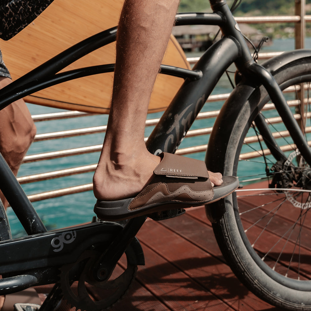 Cruiser Slide sandal on a man's right foot facing right, showing soft-rebound cushioning and arch support on pedal.