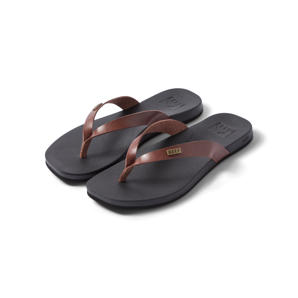Vista Lune women's flip flops facing right, close-up of brown straps and cushioned black footbed, beach-inspired comfort design.
