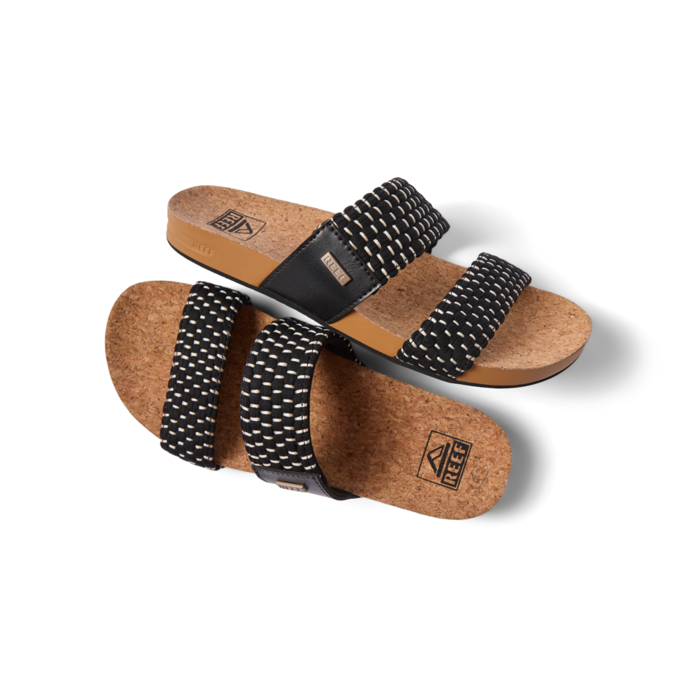 Pair of Cushion Vista women's sandals with black textile straps and cork footbed, right sandal facing left, top view close-up.