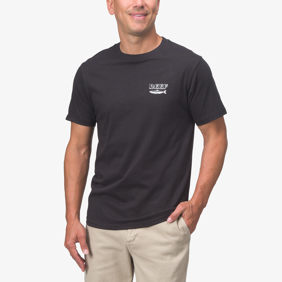 Front view of a man wearing a black Cannery Tee by REEF, designed for beach comfort and active lifestyles.