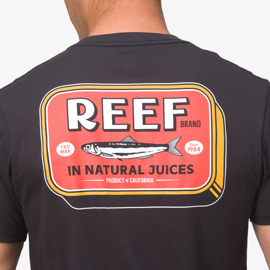 Back view of a man wearing a Cannery Tee with a bold REEF logo graphic inspired by natural beach lifestyle apparel.