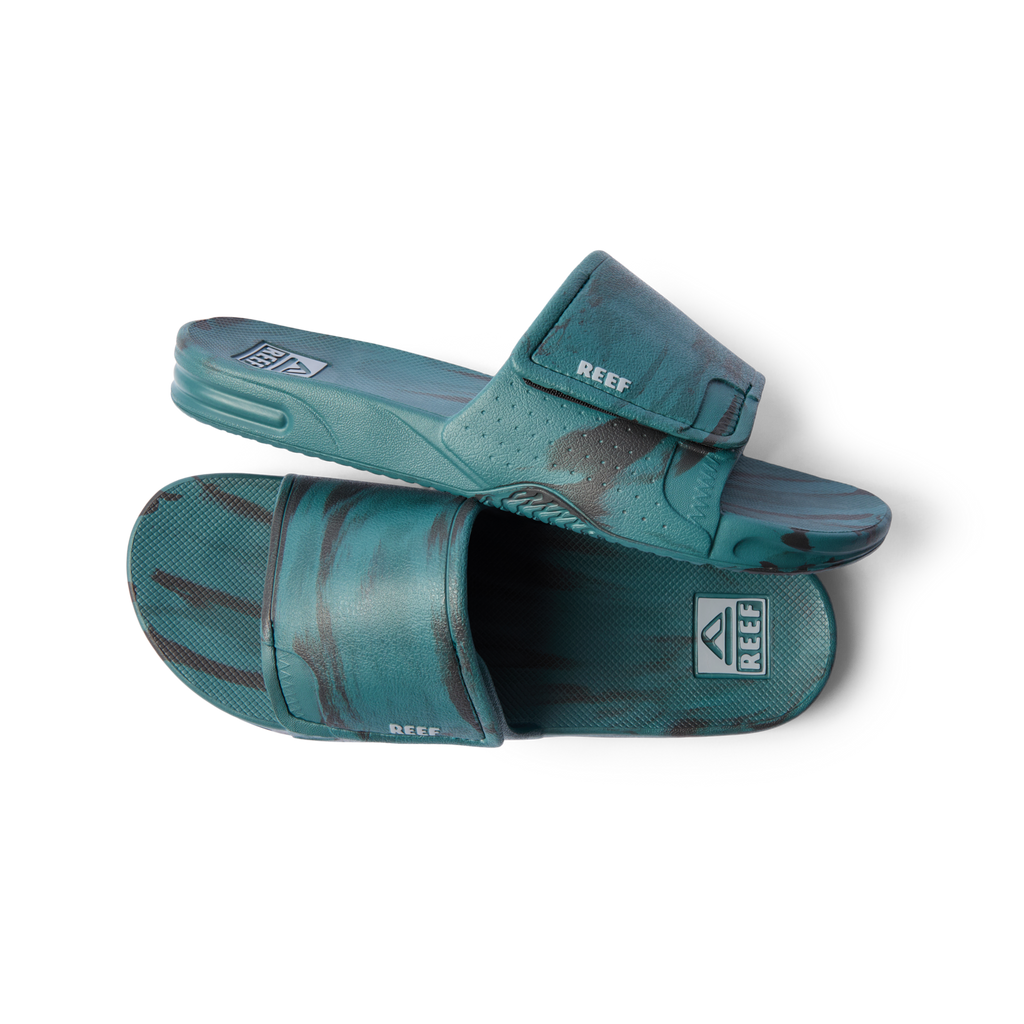 Pair of teal marble Fanning Slide H2O sandals for men, left sandal facing right, right sandal sole-up close-up view.