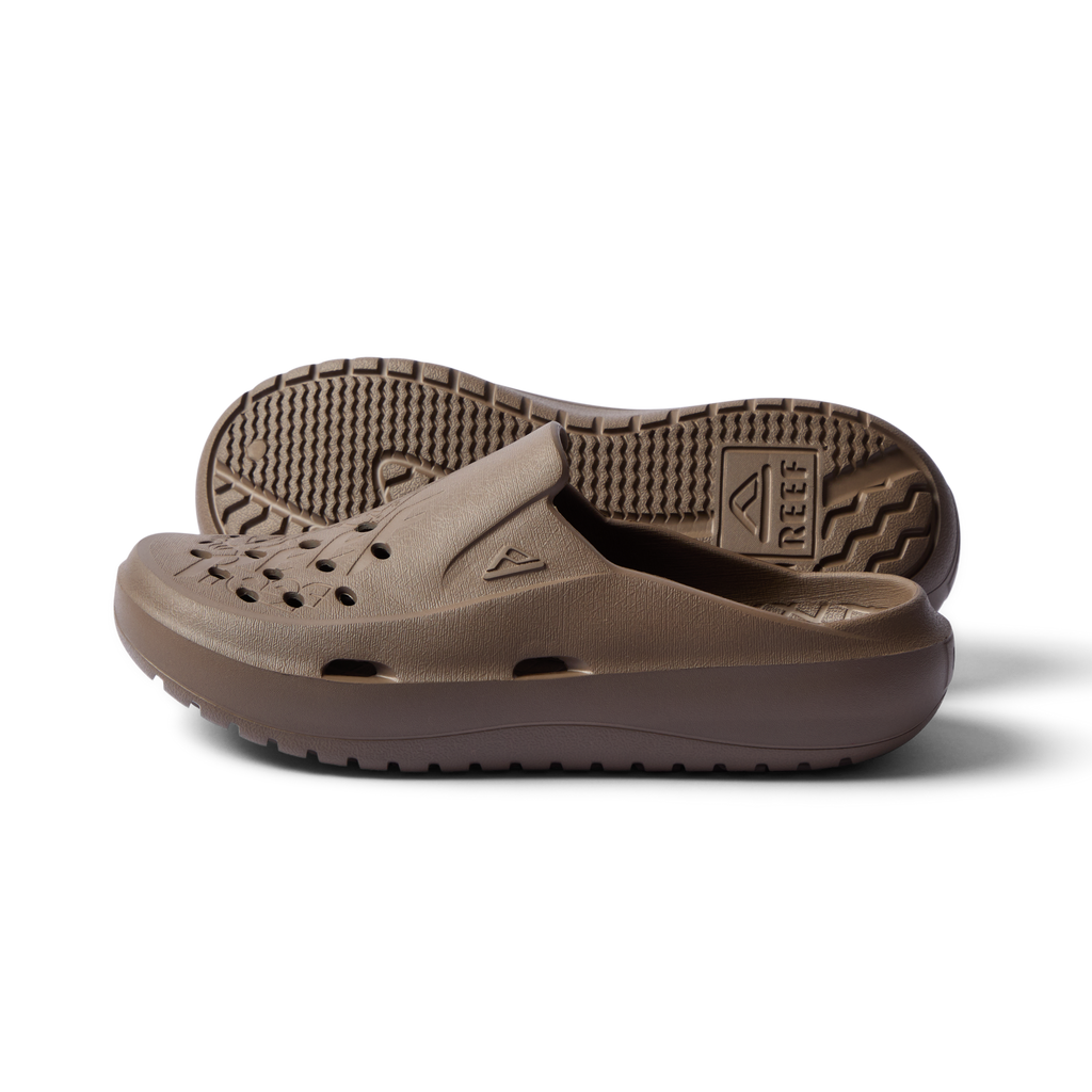 Pair of brown Glider slides facing left showing side profile and sole with water-friendly perforations and arch support.