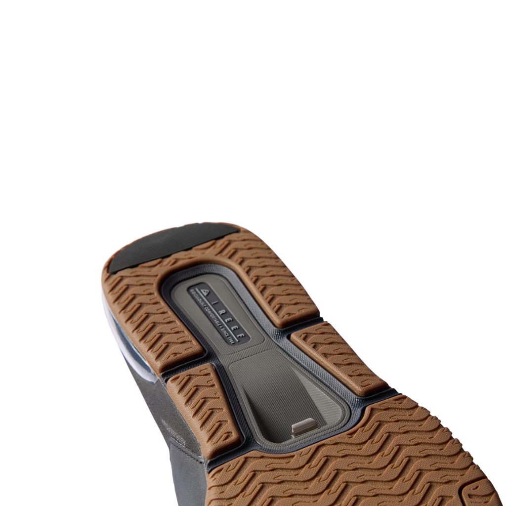Fanning + Slide sandal sole facing up, brown textured tread with black accents, showcasing oversized airbag heel cushioning.