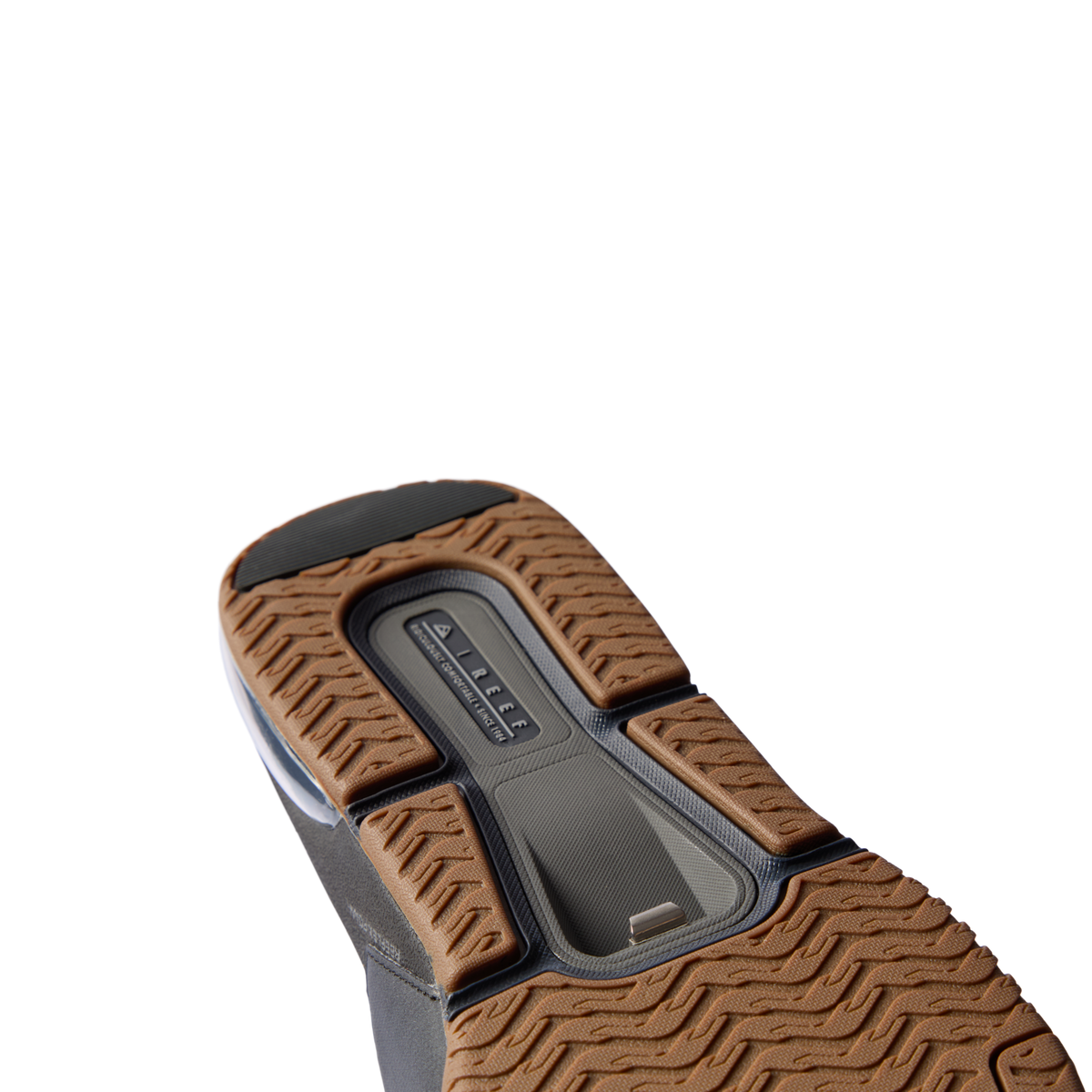 Fanning + Slide sandal sole facing up, brown textured tread with black accents, showcasing oversized airbag heel cushioning.