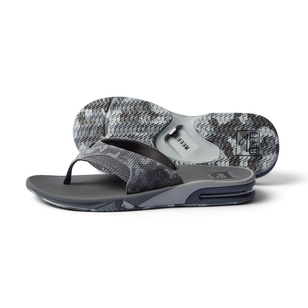 Fanning men's grey flip flop facing left, close-up on sole and cushioned footbed with anatomical arch support.