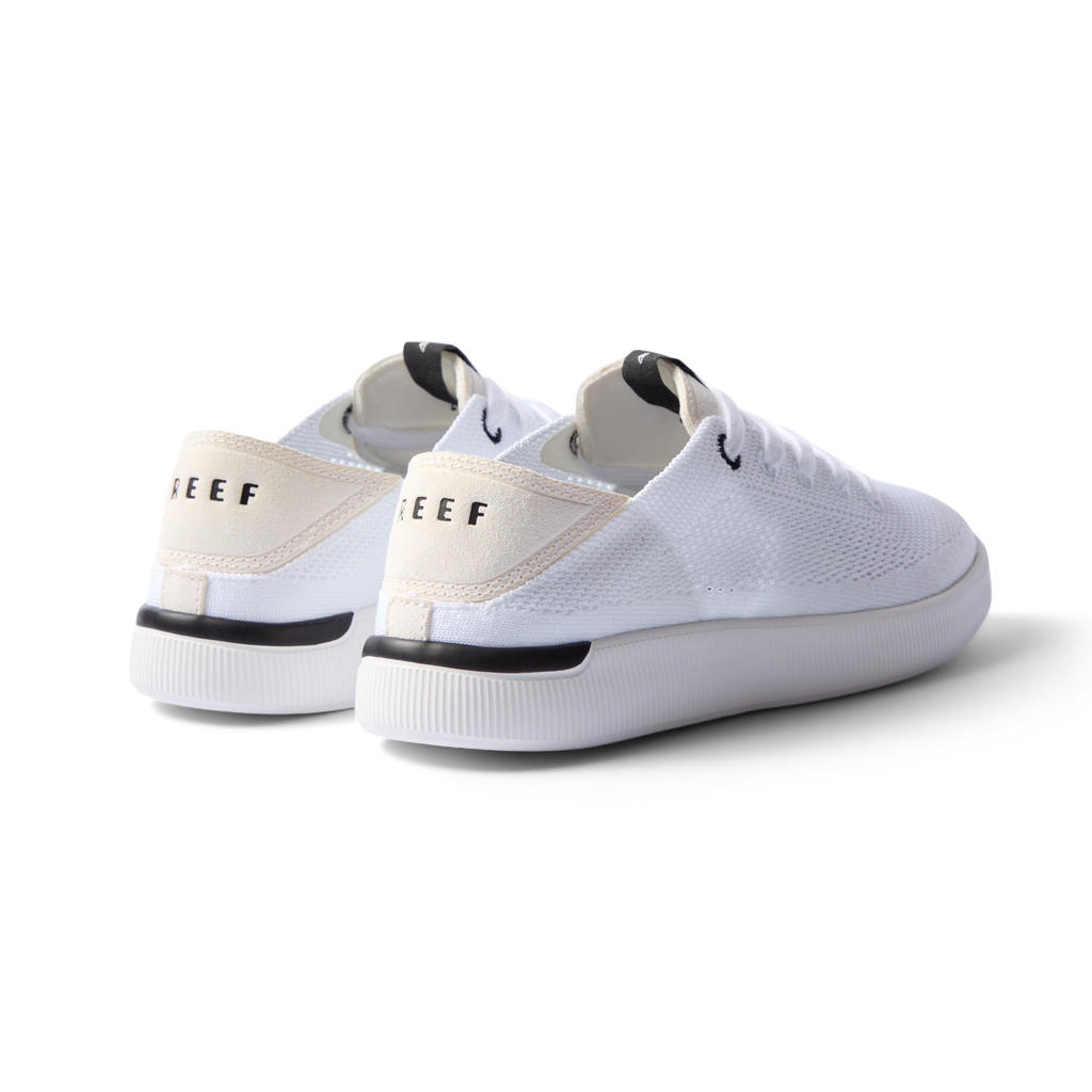 Reef Neptune white and black women's sneaker facing back right, featuring anatomical arch support and soft cushioning.