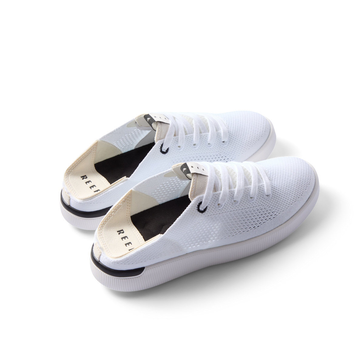Reef Neptune women's white and black sneakers facing left, featuring breathable knit upper and cushioned sole for all-day comfort.