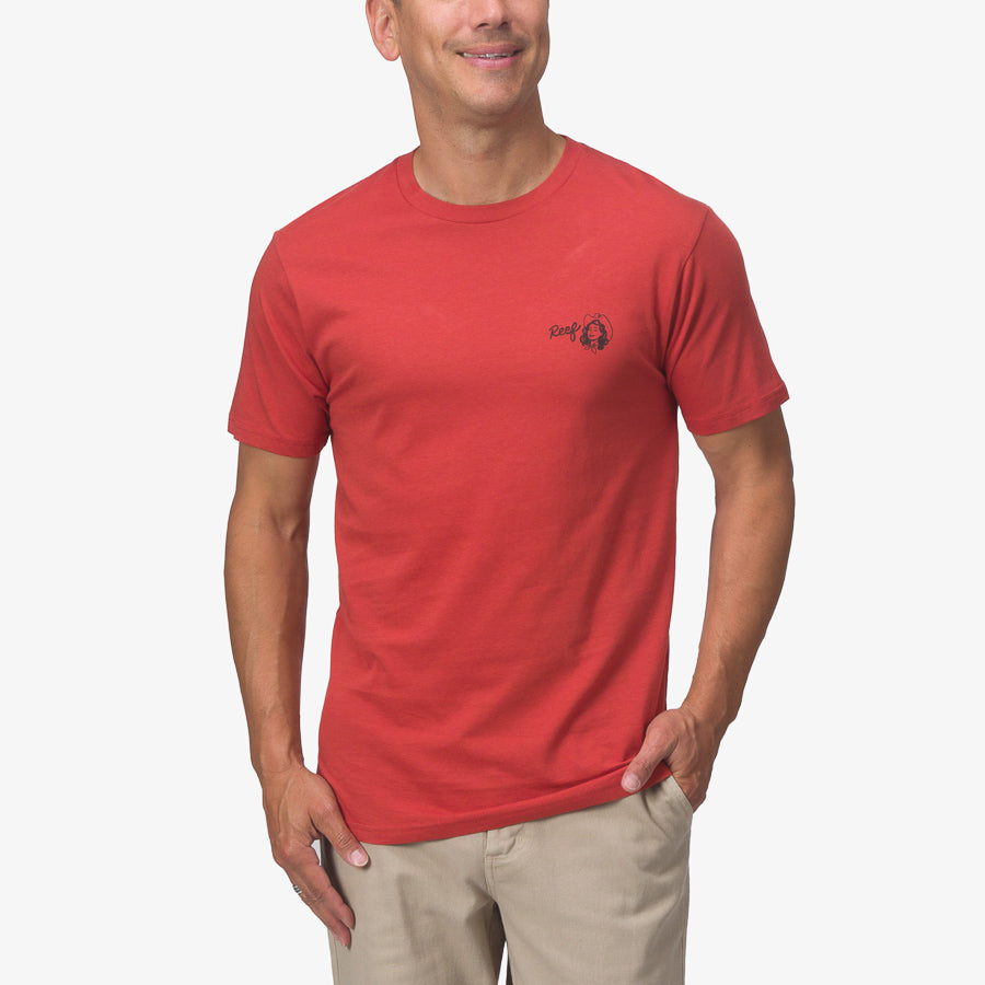 Man wearing a cinnabar red Cowmaid Tee facing forward, featuring soft fabric and a small chest logo on the left side.