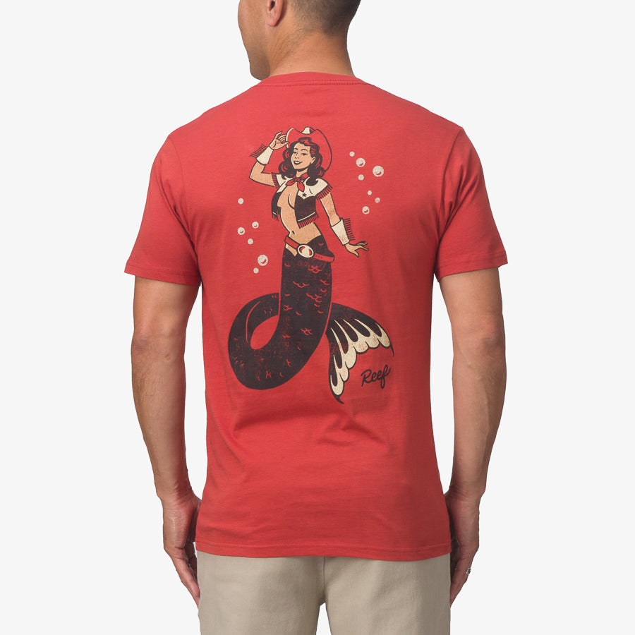 Man wearing red Cowmaid Tee showing back with surf-inspired mermaid graphic for beach comfort style