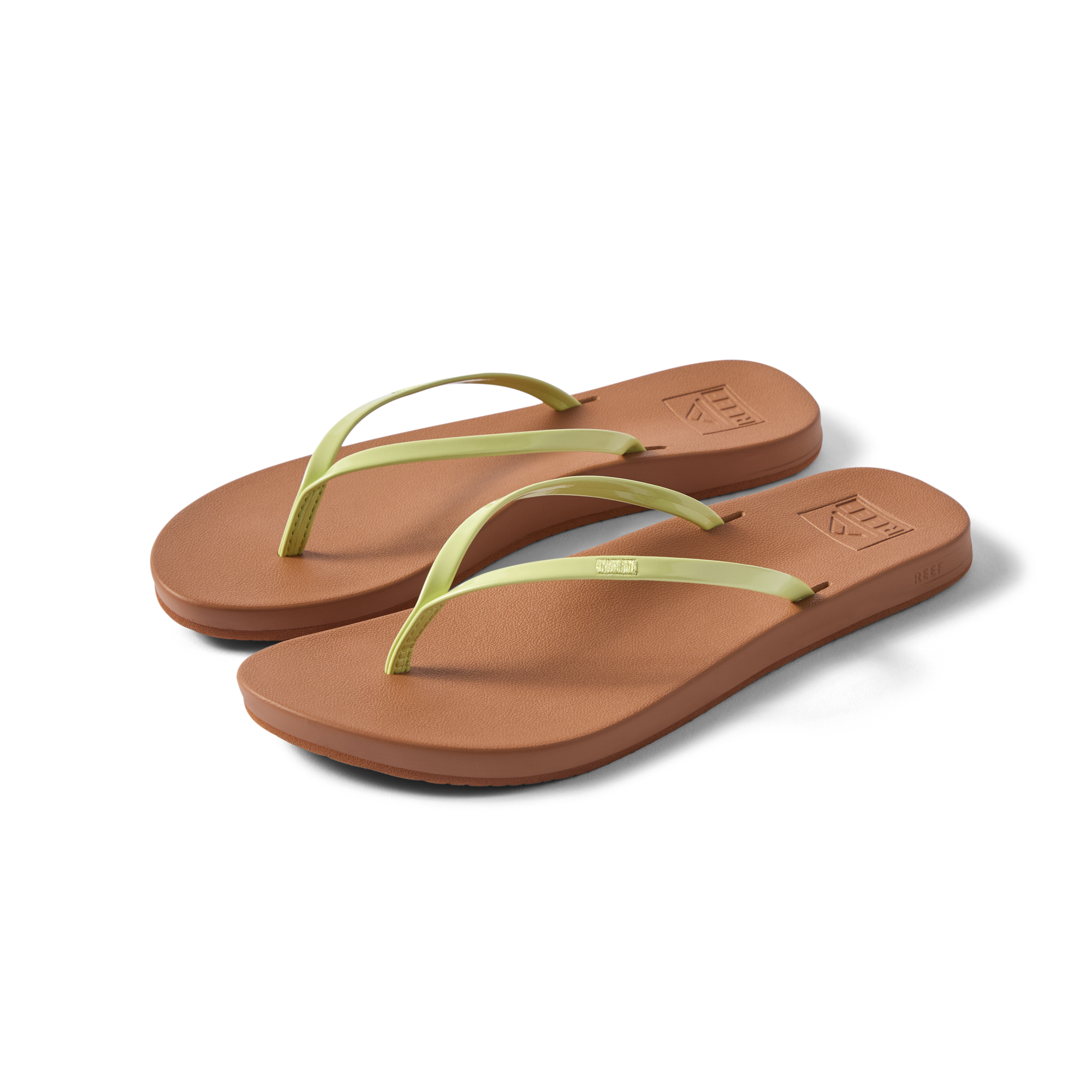 Pair of Cushion Slim women's flip flops facing right, lime green straps and brown cushioned footbed, beach-inspired comfort shoes.