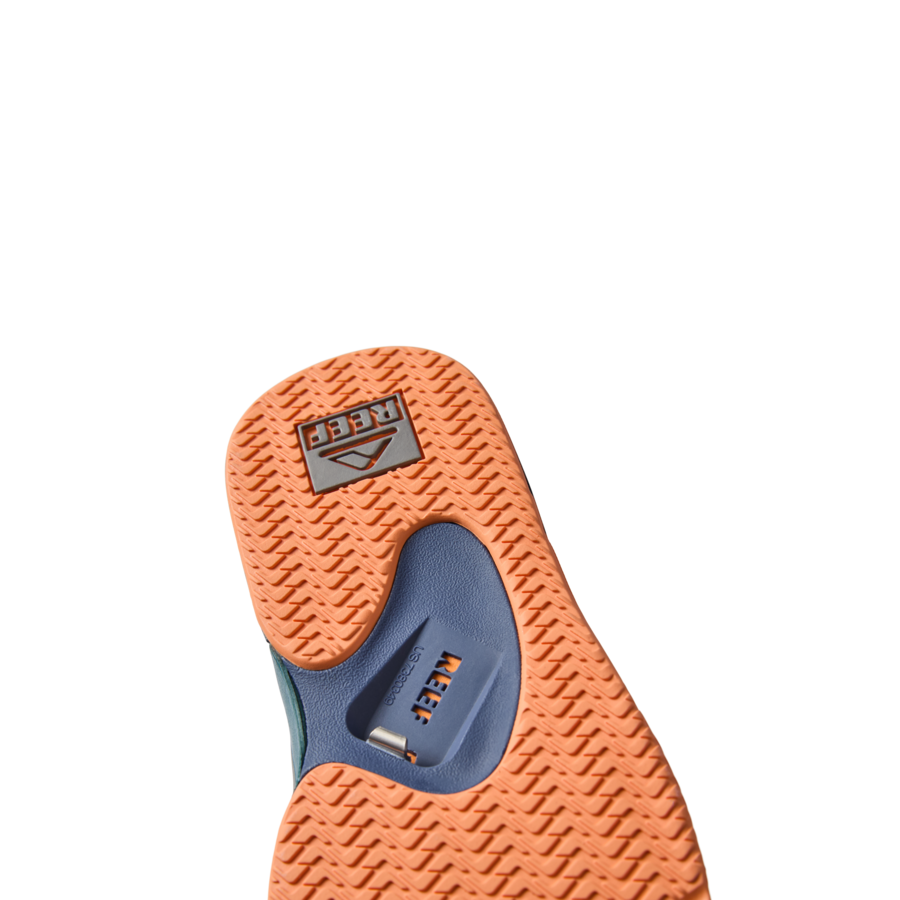 Fanning men's shoe showing orange sole with textured grip and blue arch support, surf-inspired comfort and durability.