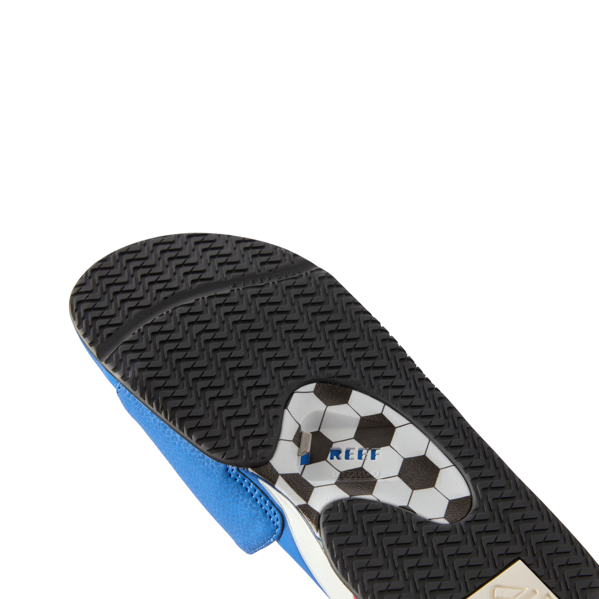 Fanning Slide men's sandal sole facing up showing hexagonal tread pattern, REEF logo, and built-in bottle opener detail.