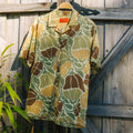 Men's Sullivan's Camp Shirt - Floral Camo hanging on wooden gate, lightweight with relaxed fit and surf-inspired style